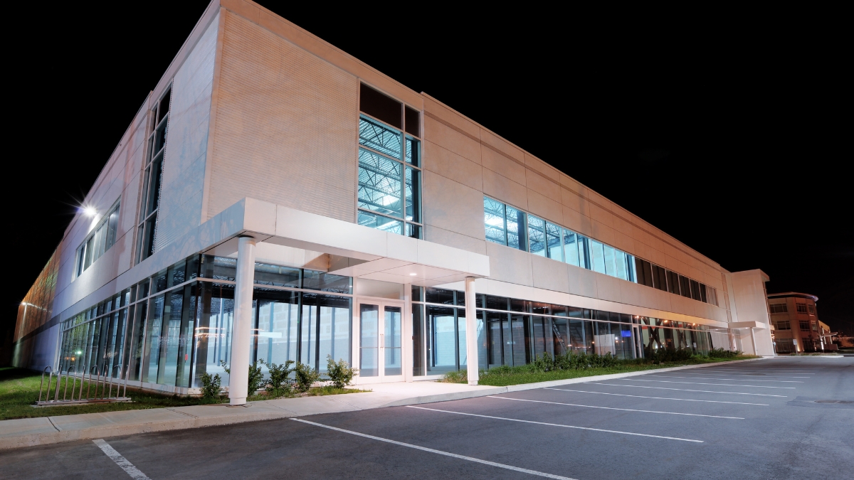 Professional cleaning team maintaining a modern office exterior after business hours.